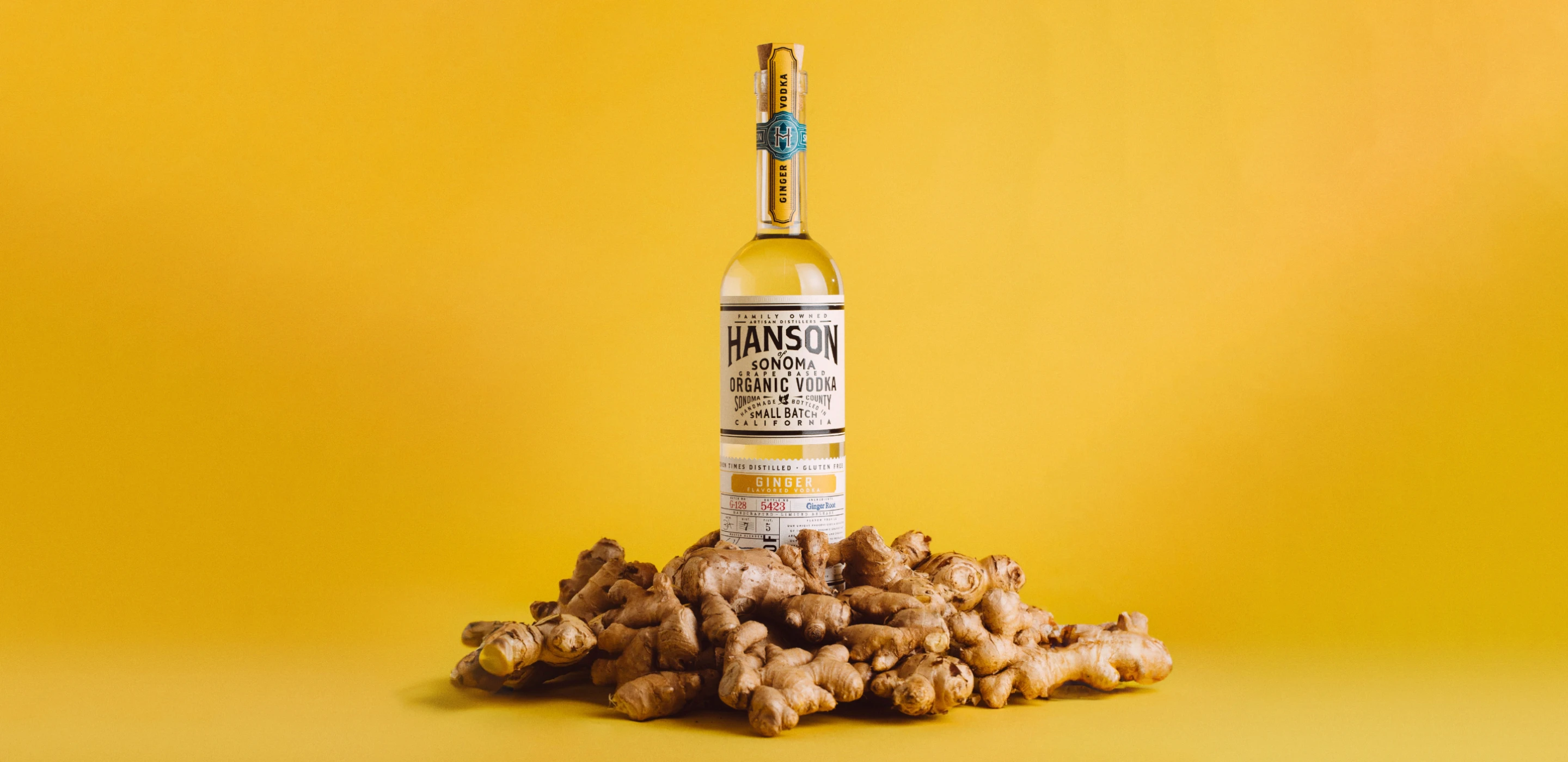 Ginger Flavour Vodka Bottle surrounded by ginger root