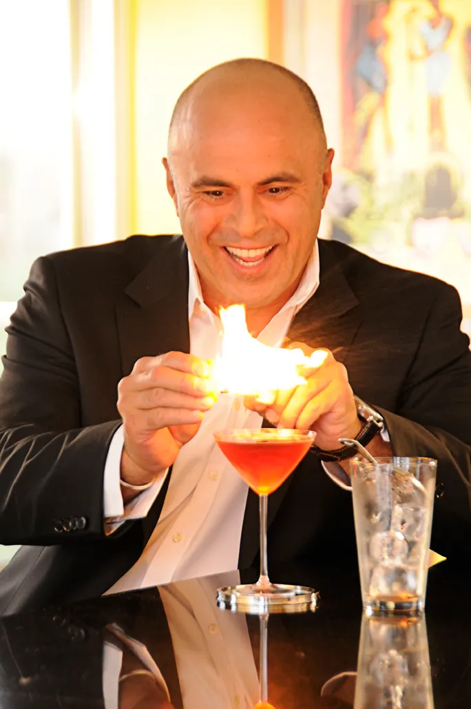 Portrait of Toby Abou-Ganim lighting flaming cocktail on fire