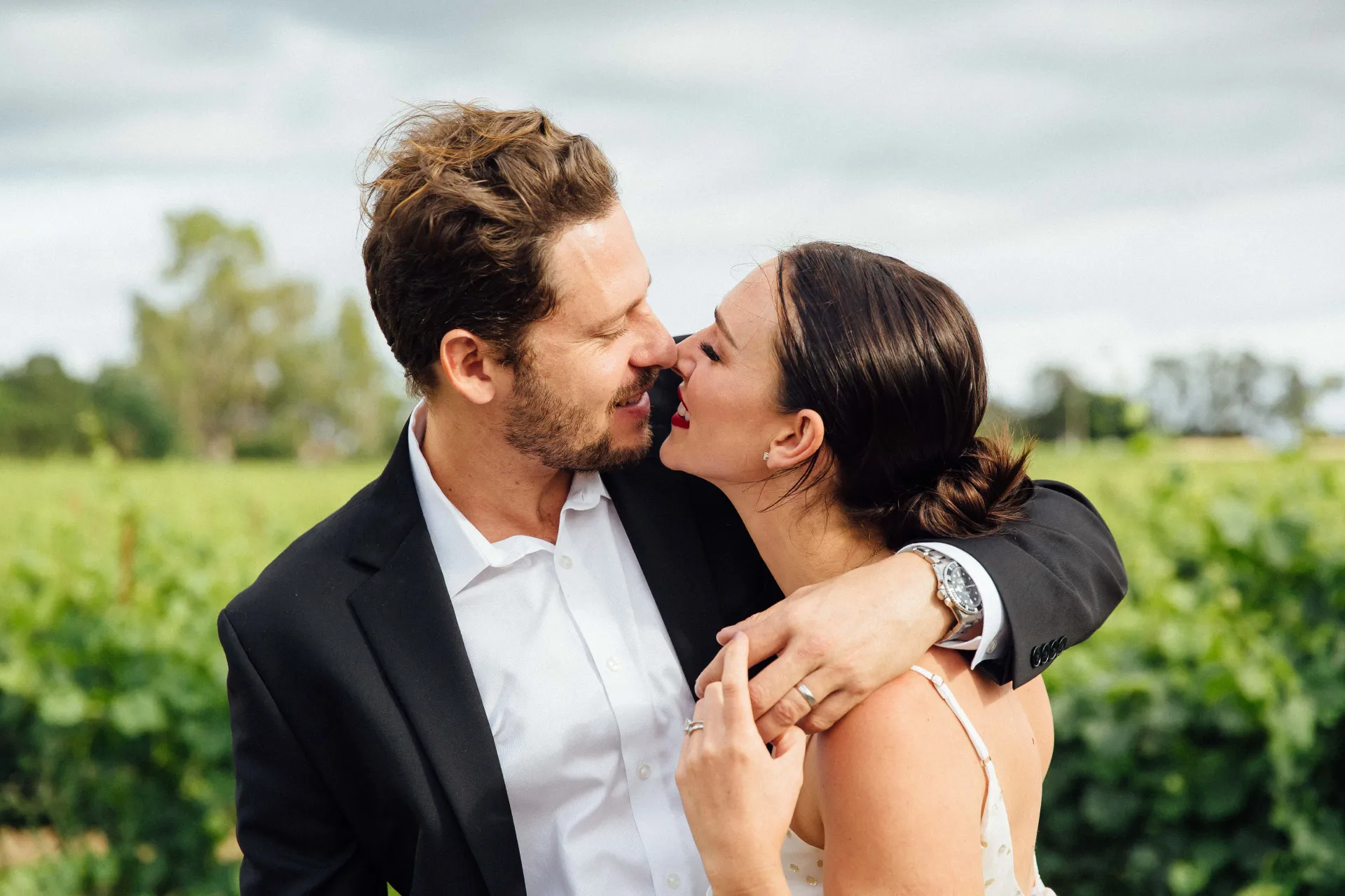 brandon hanson and his wife on their wedding day in front of the vineyard