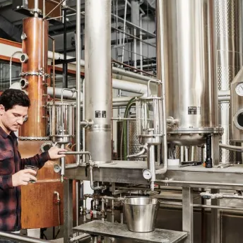 Man operating distillery equipment